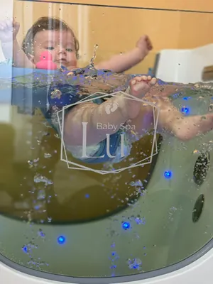 Beba u plavom kolutu, gledana kroz staklenu stijenu kadice Baby Spa Lu.