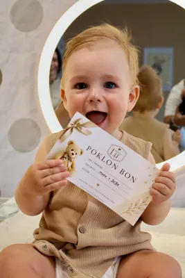 Beba na podlozi drži poklon-bon Baby Spa Lu.