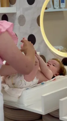 Roditelj masira bebine noge na podlozi za masažu.