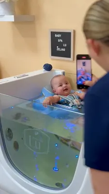 Roditelj uz bebu koja boravi u plavom kolutu u kadici.